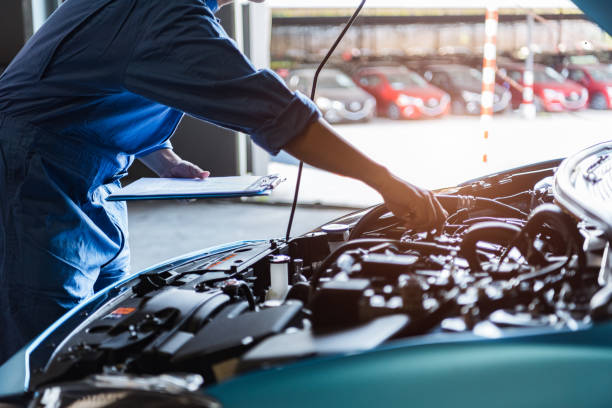A mechanic is inspecting a engine of car