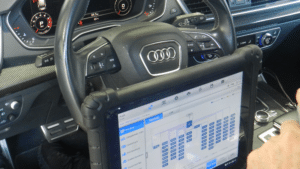 An Audi-certified technician meticulously inspects an Audi engine bay with specialized diagnostic equipment.