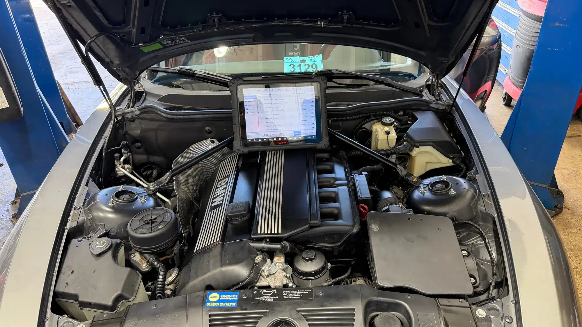 BMW engine undergoing advanced diagnostic testing with professional automotive equipment