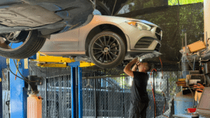 A Mercedes-Benz technician meticulously operates advanced diagnostic equipment connected to a luxury vehicle.