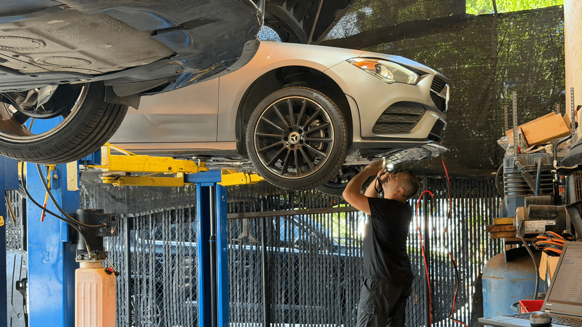 A Mercedes-Benz technician meticulously operates advanced diagnostic equipment connected to a luxury vehicle.